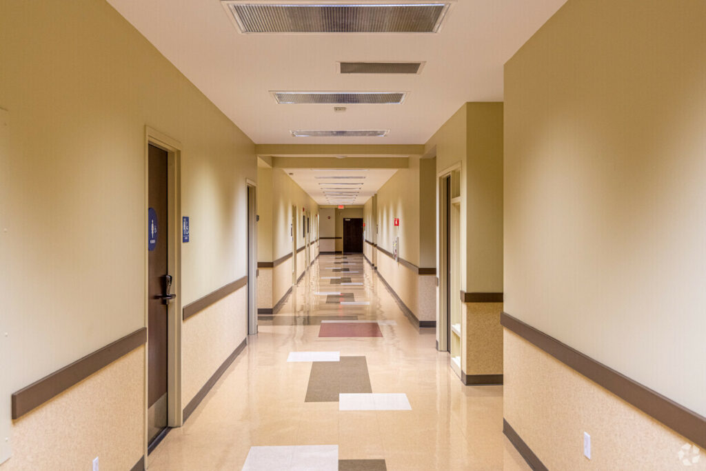 Common hallway with doors of private bathrooms, suites, lining the length.