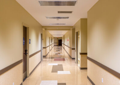 Common hallway with doors of private bathrooms, suites, lining the length.