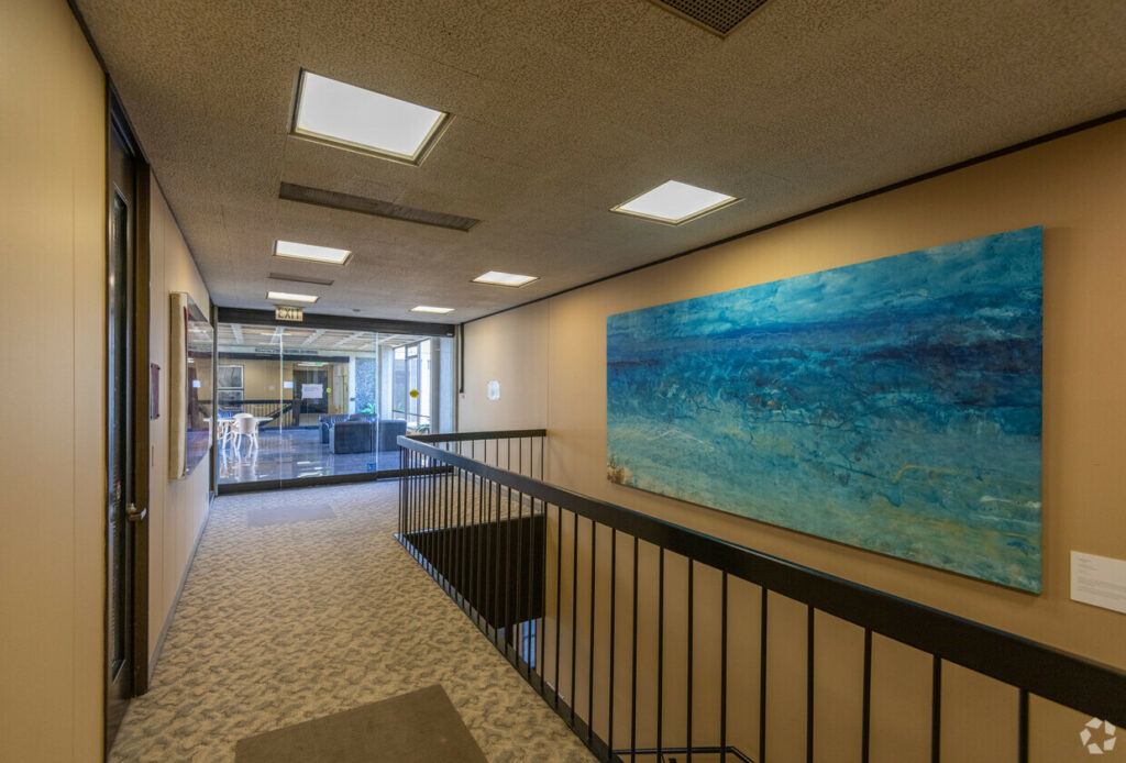 Common area stairwell and hallway, with view of common Lobby through glass wall.