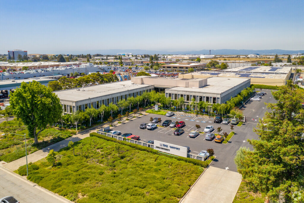 Aerial view of the Oakport Building and parking lot. The Santa Cruz Mountains are visible across the bay.