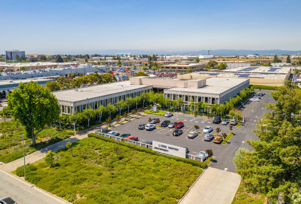 Aerial view of the Oakport Building and parking lot. The Santa Cruz Mountains are visible across the bay.