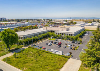 Aerial view of the Oakport Building and parking lot. The Santa Cruz Mountains are visible across the bay.