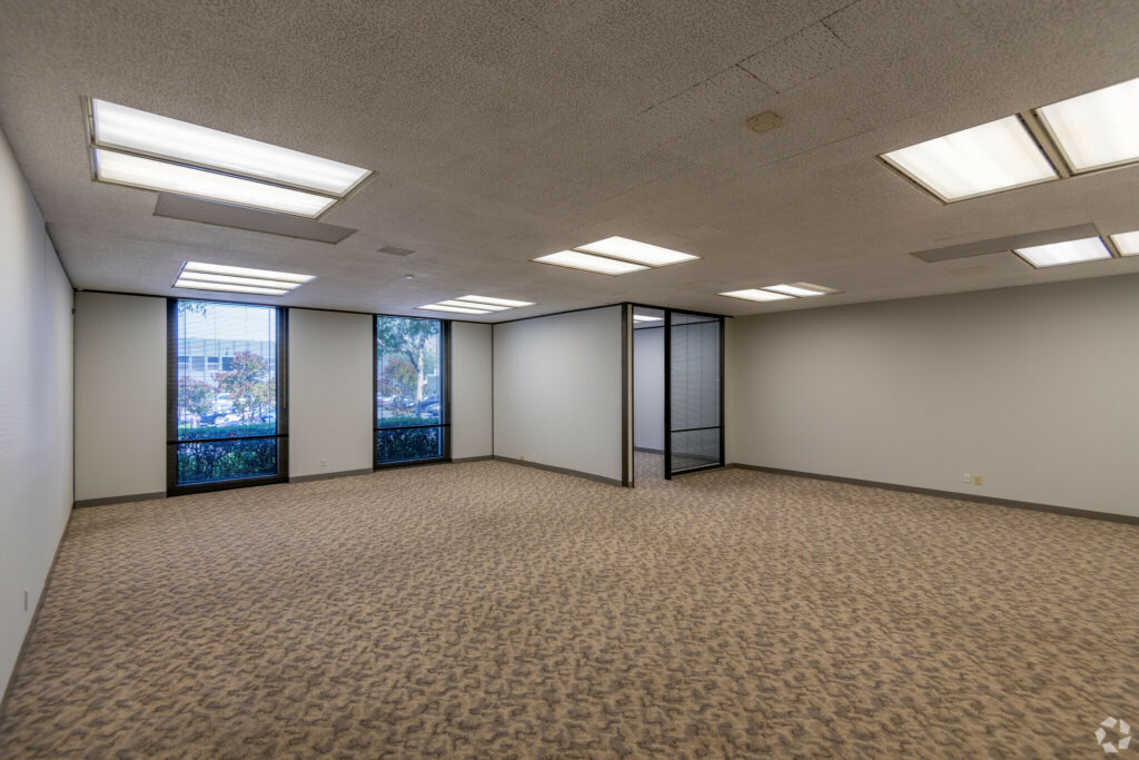 Open Bullpen area in Suite. Private corner office and two floor-to-ceiling windows line the back wall.