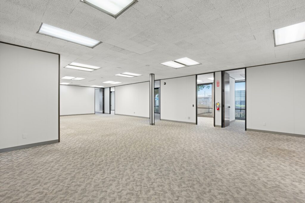 The main open space of Suite. Four private offices with large windows line the back walls.