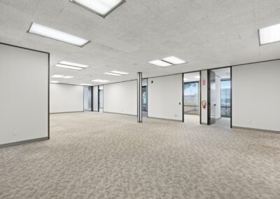 The main open space of Suite. Four private offices with large windows line the back walls.