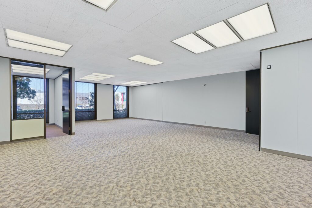 The main open space of Suite. A private corner office and floor-to-ceiling windows line the back walls.