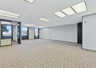 The main open space of Suite. A private corner office and floor-to-ceiling windows line the back walls.