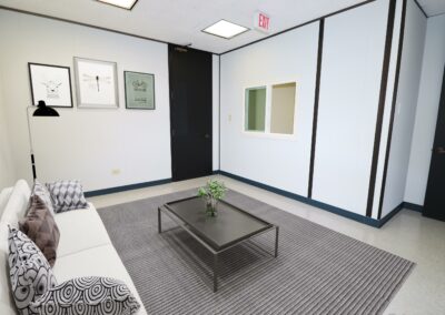 Virtually staged Private waiting area/lounge with full size couch and mounted TV in Suite.